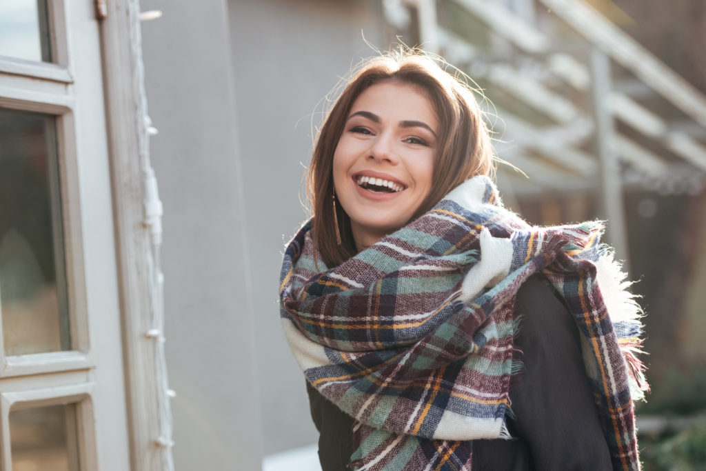 graphicstock image of young laughing lady looking at camera while walking near cafe outdoors HOxI3hRLne 1